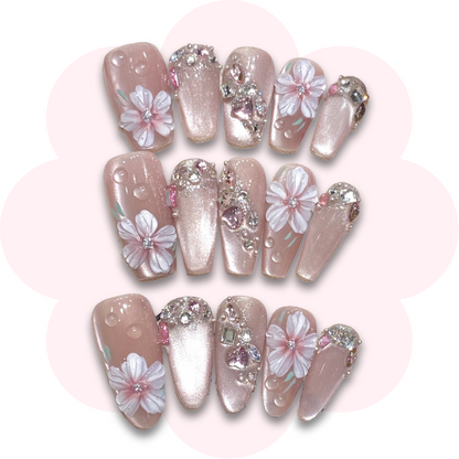 Japanese cherry blossom press on nail featuring a delicate cherry blossom flowers, on a soft cat eye pink pastel tones for an elegant, feminine nail art