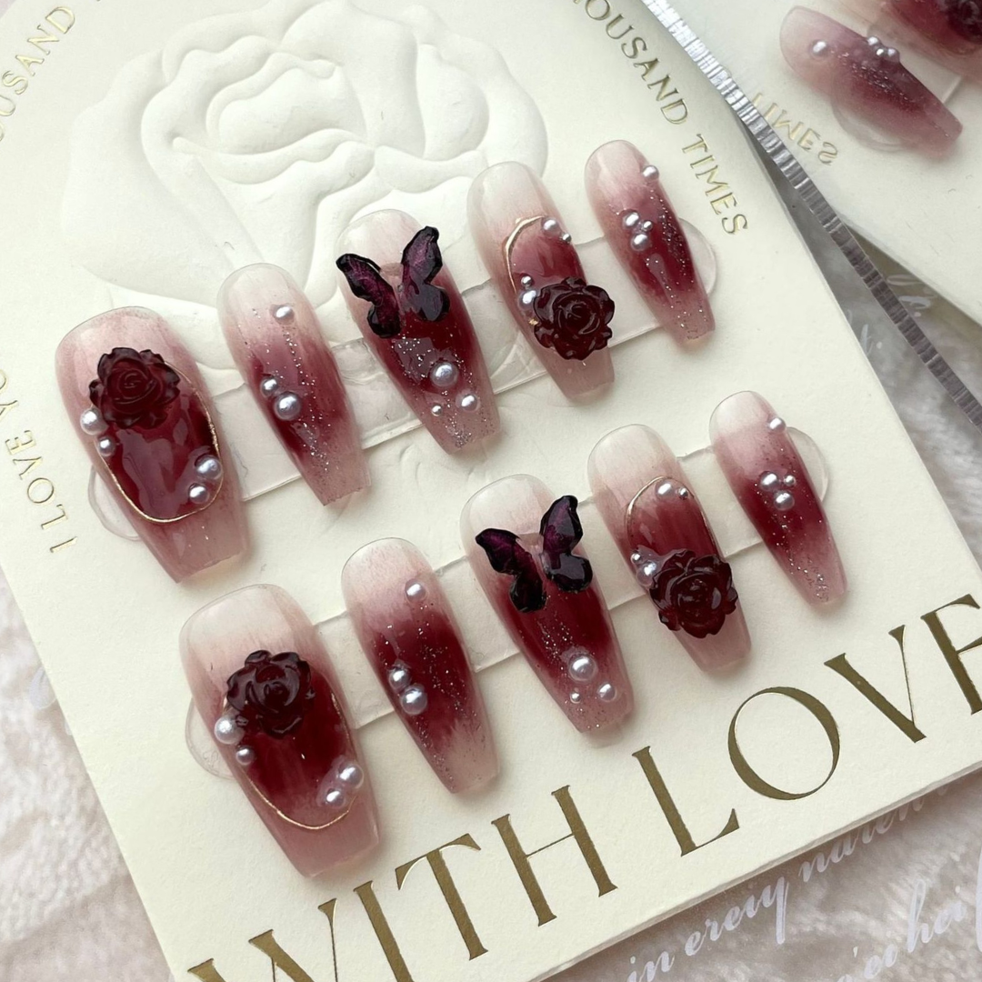 Elegant burgundy press on nails featuring delicate butterfly for a whimsical beauty.