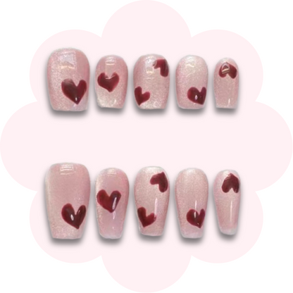 valentines day inspired long lasting reusable press on nails featuring simple heart design on a pink cats eye base color