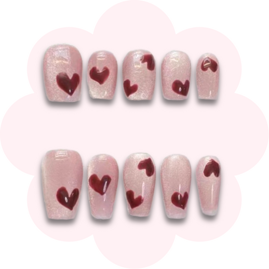 valentines day inspired long lasting reusable press on nails featuring simple heart design on a pink cats eye base color
