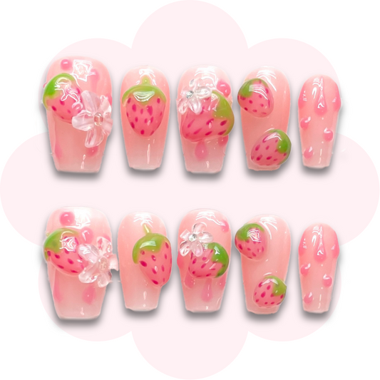 strawberry bliss short coffin press on nails with a cute strawberry themed design, pink tones, glossy finish and long lasting, easy to apply manicure.