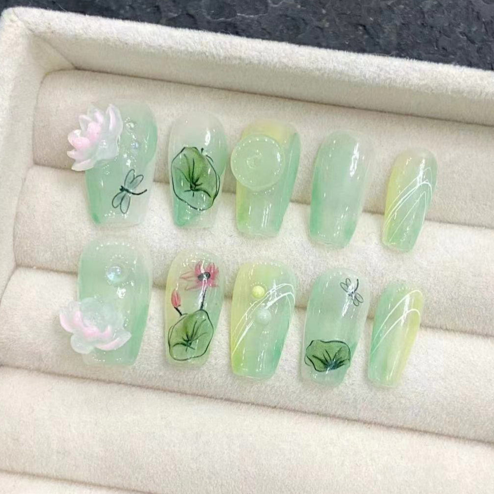 zen lotus nail design featuring pink 3d lotus and leaves on a light green base press on false nails